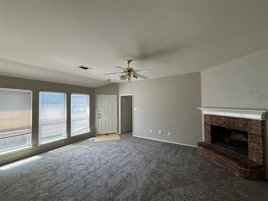 an empty room with windows and fireplace