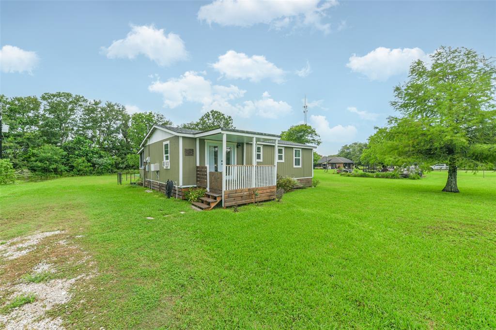 a view of a house with a big yard and large trees