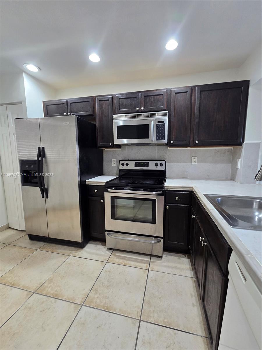 a kitchen with a stove a microwave and a sink