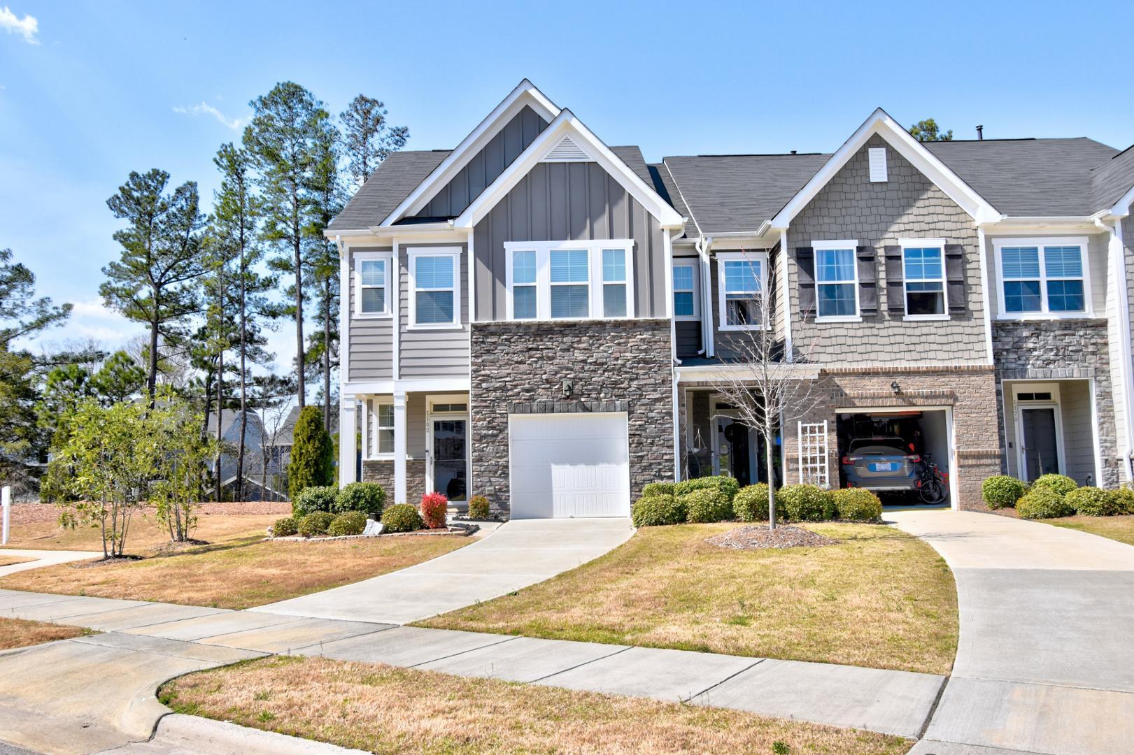 a view of a brick house with a yard in front of it