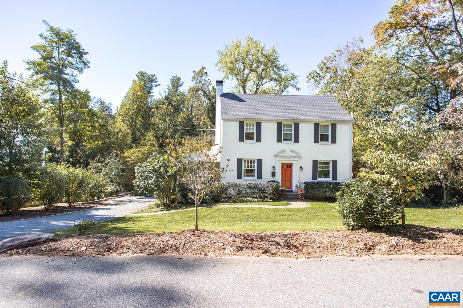 a front view of a house with a yard and trees