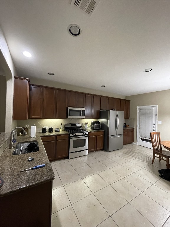 a kitchen with furniture a sink and a stove top oven with wooden floor