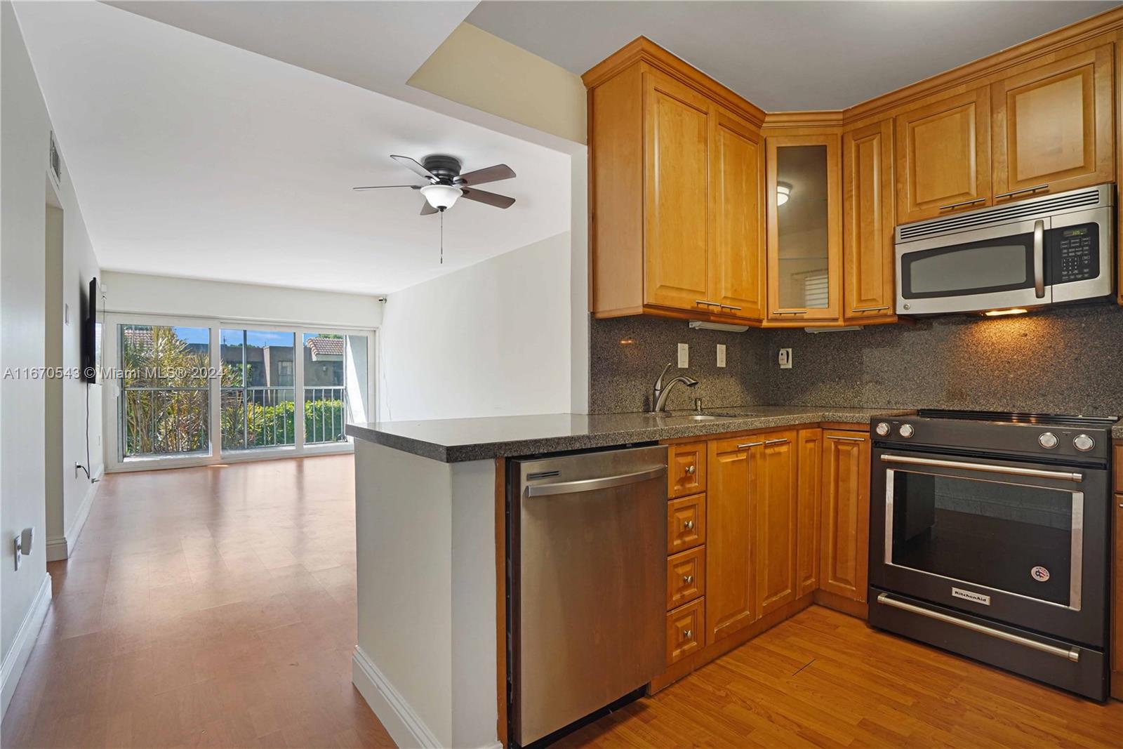 a kitchen with stainless steel appliances granite countertop a stove a sink and a microwave