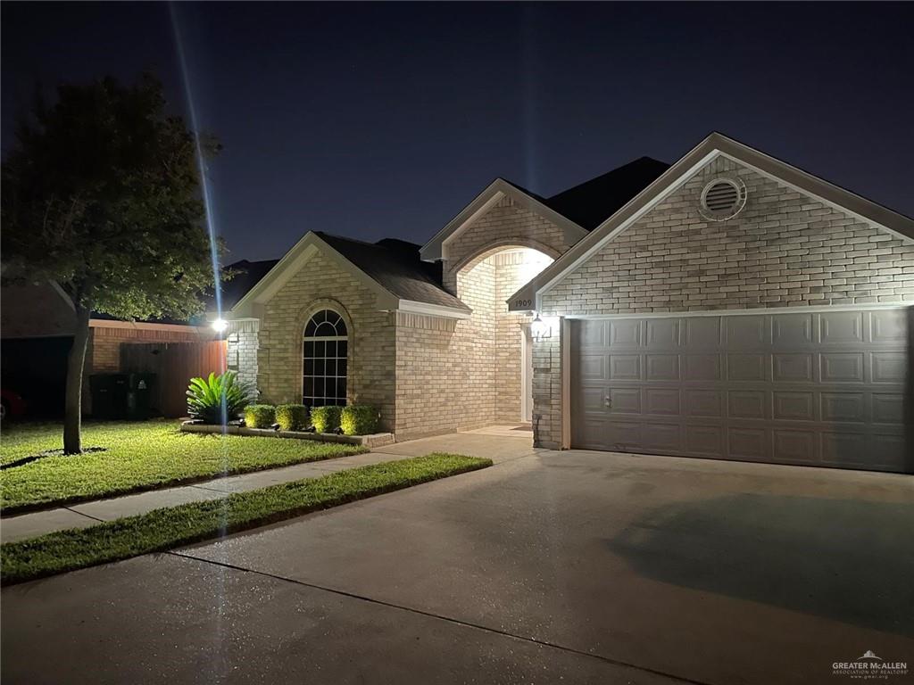 View of front of property featuring a lawn and a garage