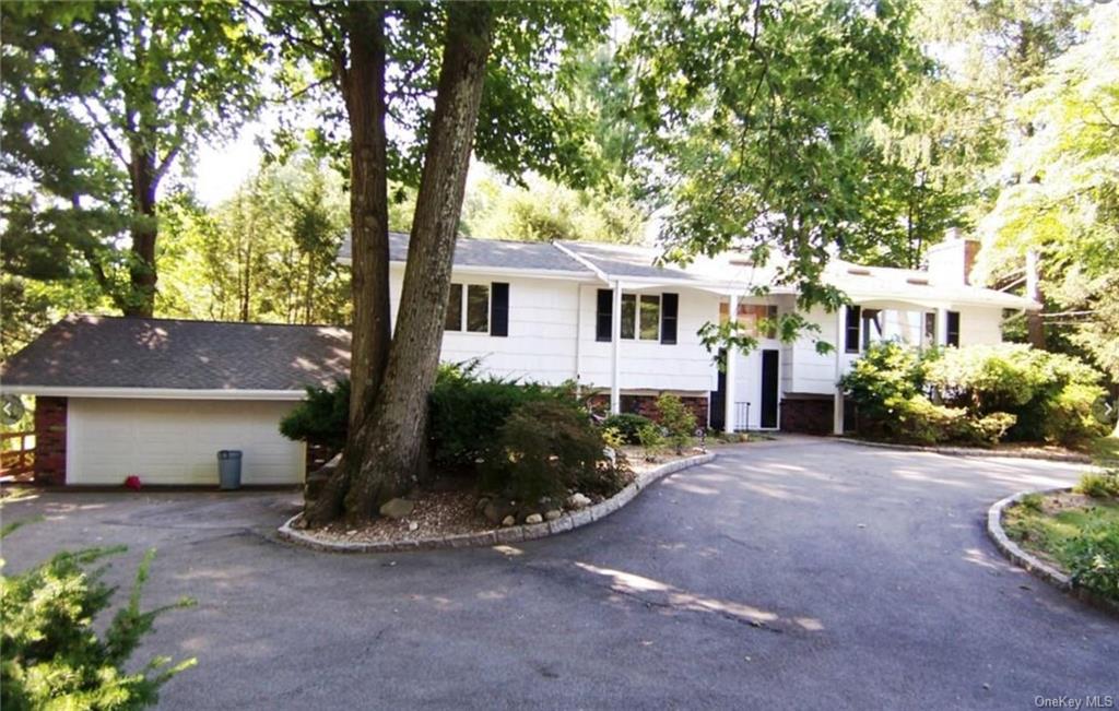 a front view of a house with a yard and a garden