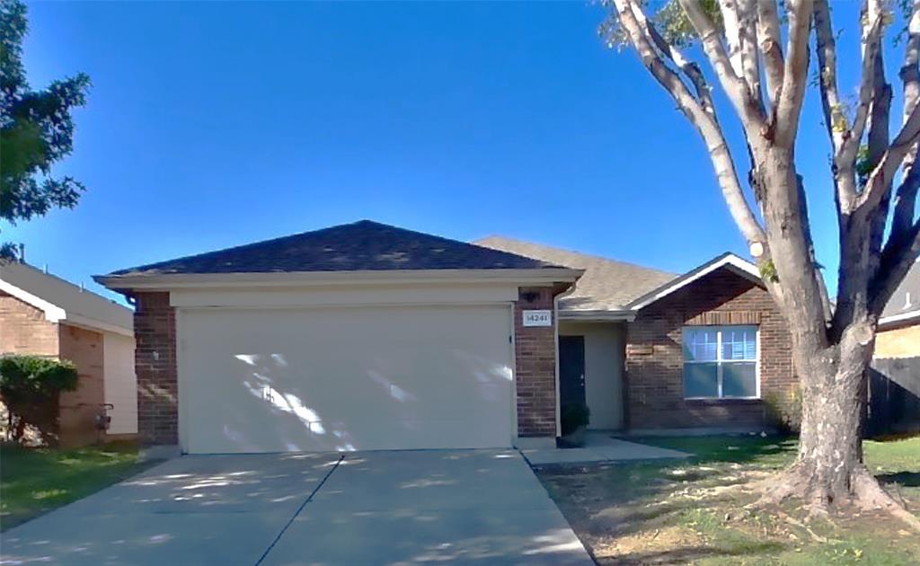 a front view of a house with yard and tree