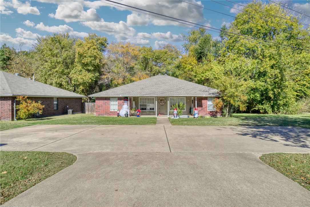 Single story home featuring a porch and a front ya