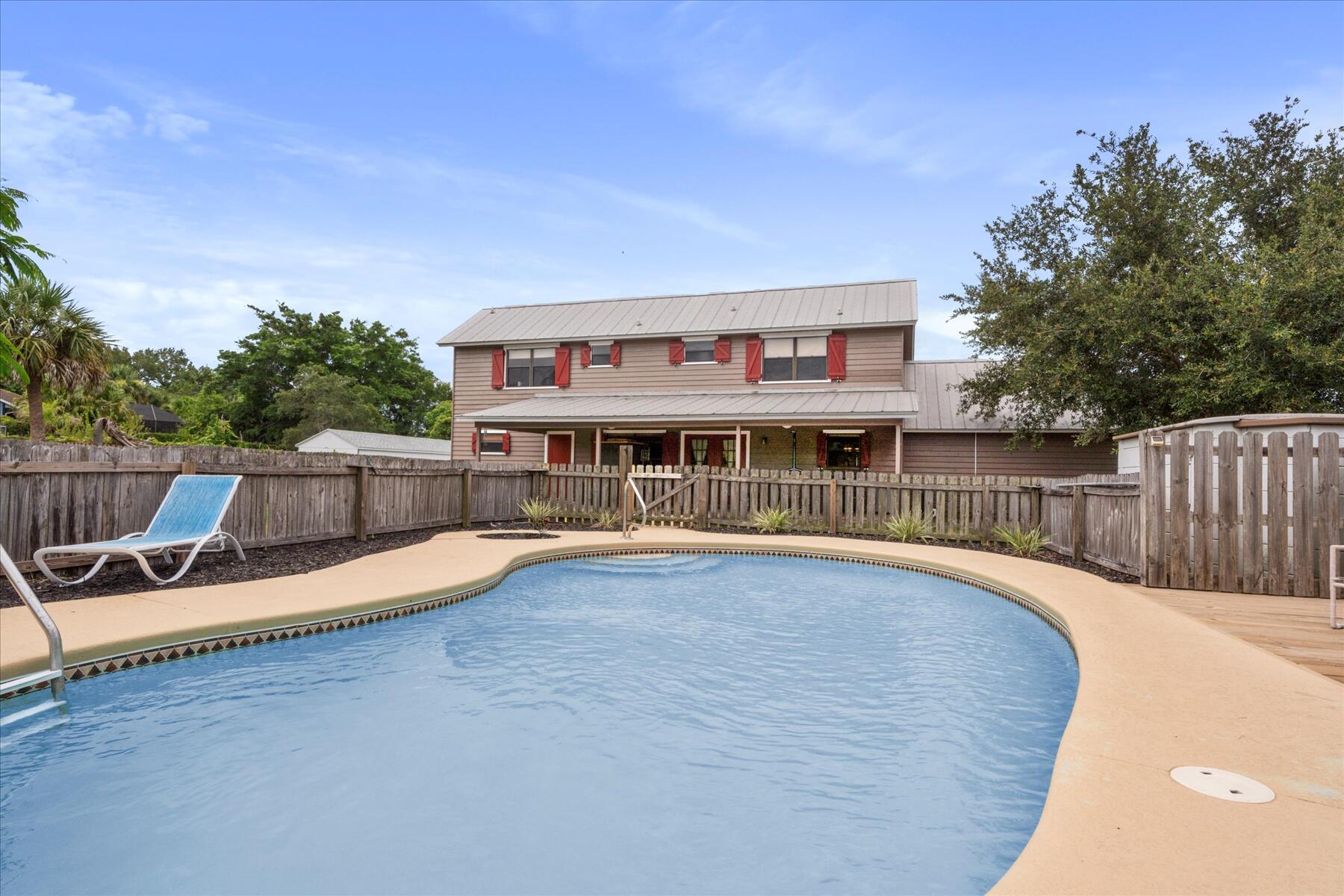 a view of a house with pool and chairs