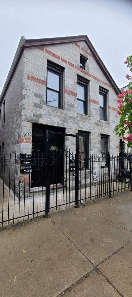 a front view of a house with iron fence