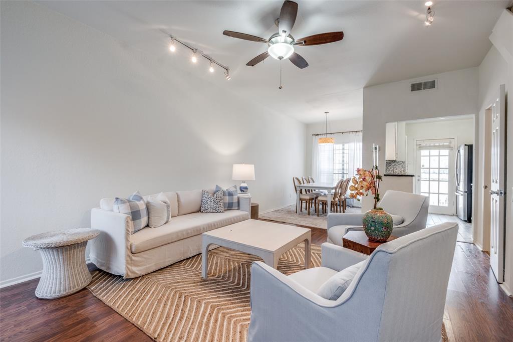 a living room with furniture a chandelier and a wooden floor