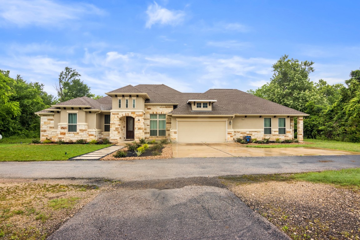 a view of a big house with a big yard and large trees