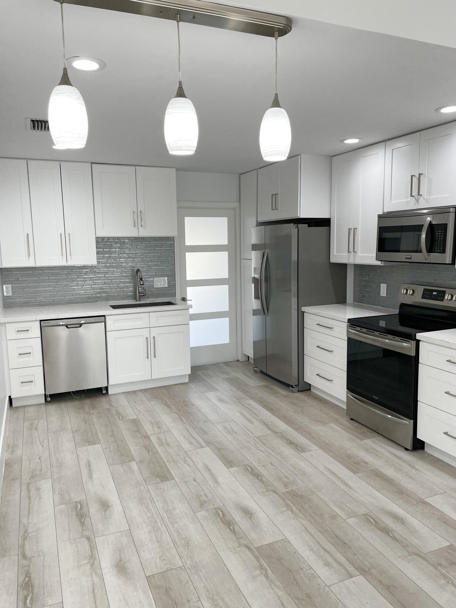 a kitchen with stainless steel appliances a stove a refrigerator and a sink