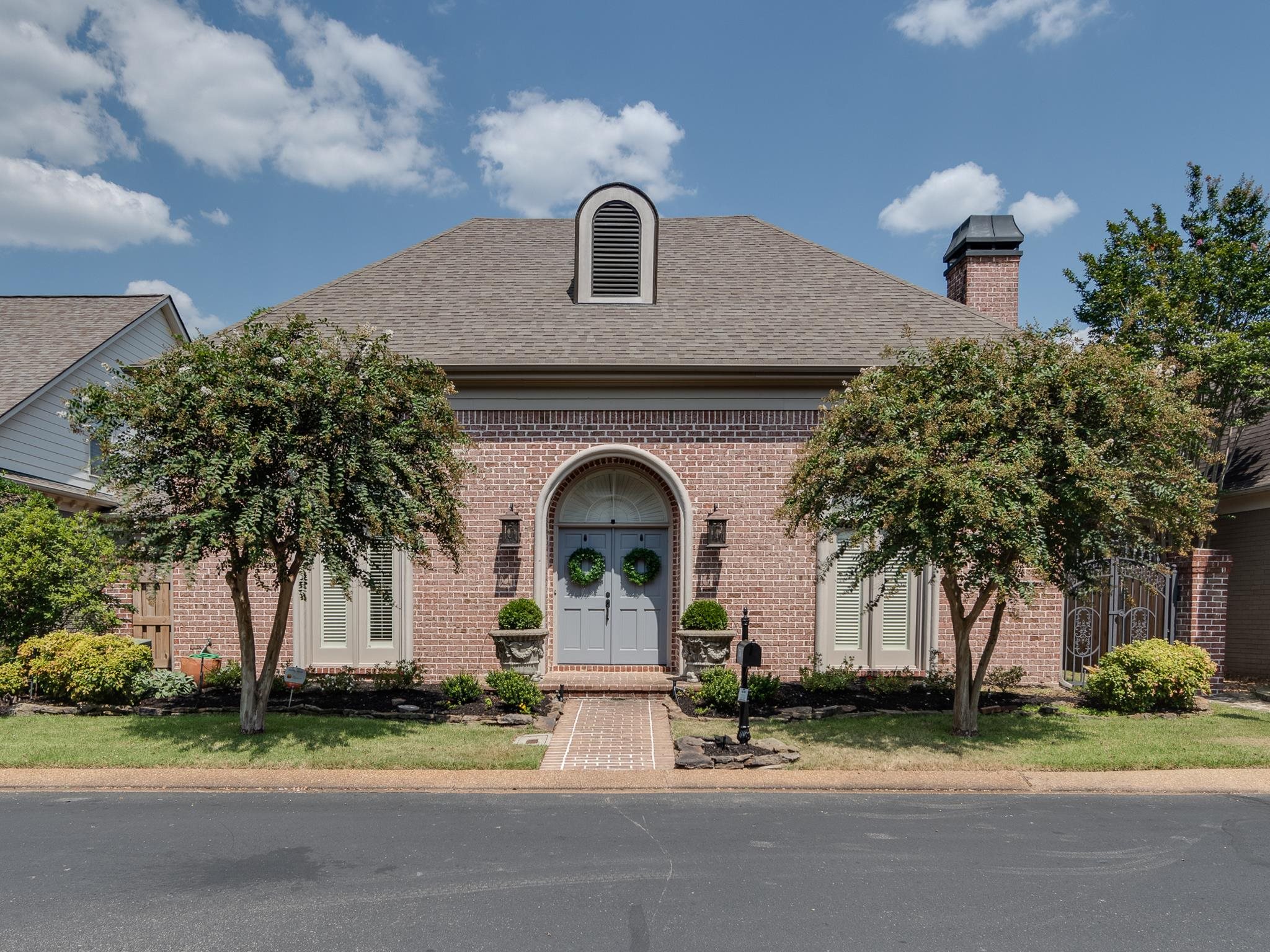 a front view of a house with a garden