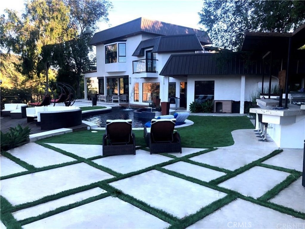 a front view of a house with garden and sitting area