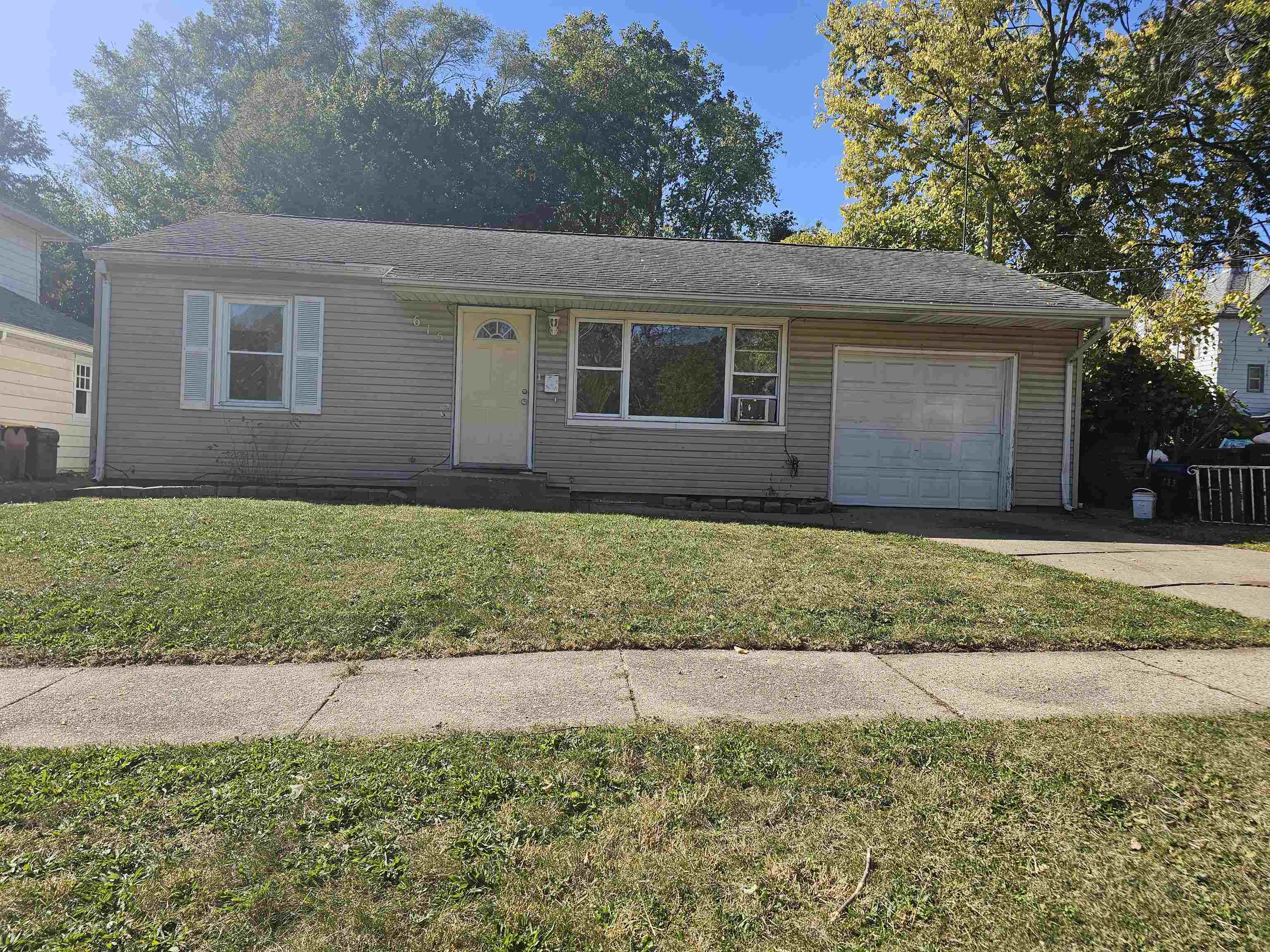 a front view of a house with a yard and trees