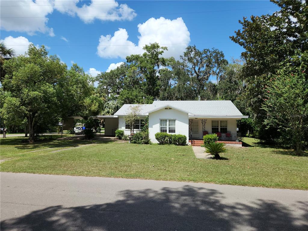 a view of a house with a yard and sitting area