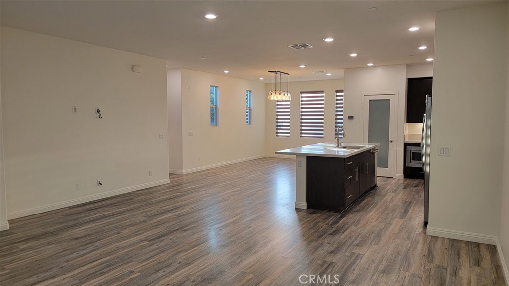 a kitchen with stainless steel appliances granite countertop a sink a stove and a wooden floors