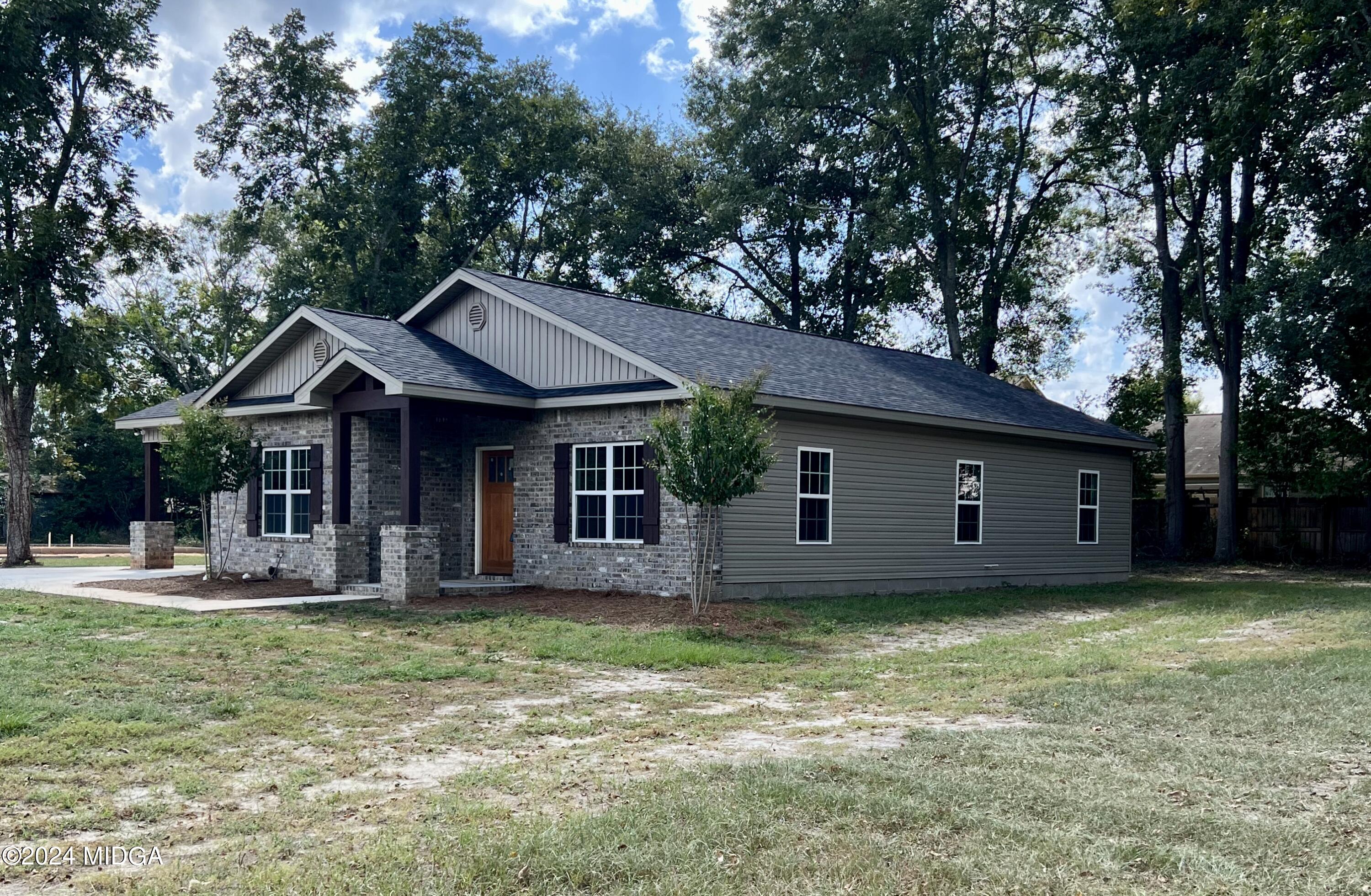 a view of a house with a yard and sitting area