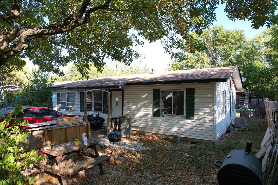 a front view of a house with yard furniture and trees