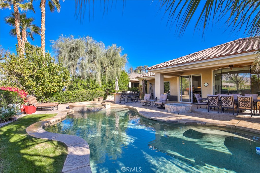 a view of a swimming pool with dining table and chairs