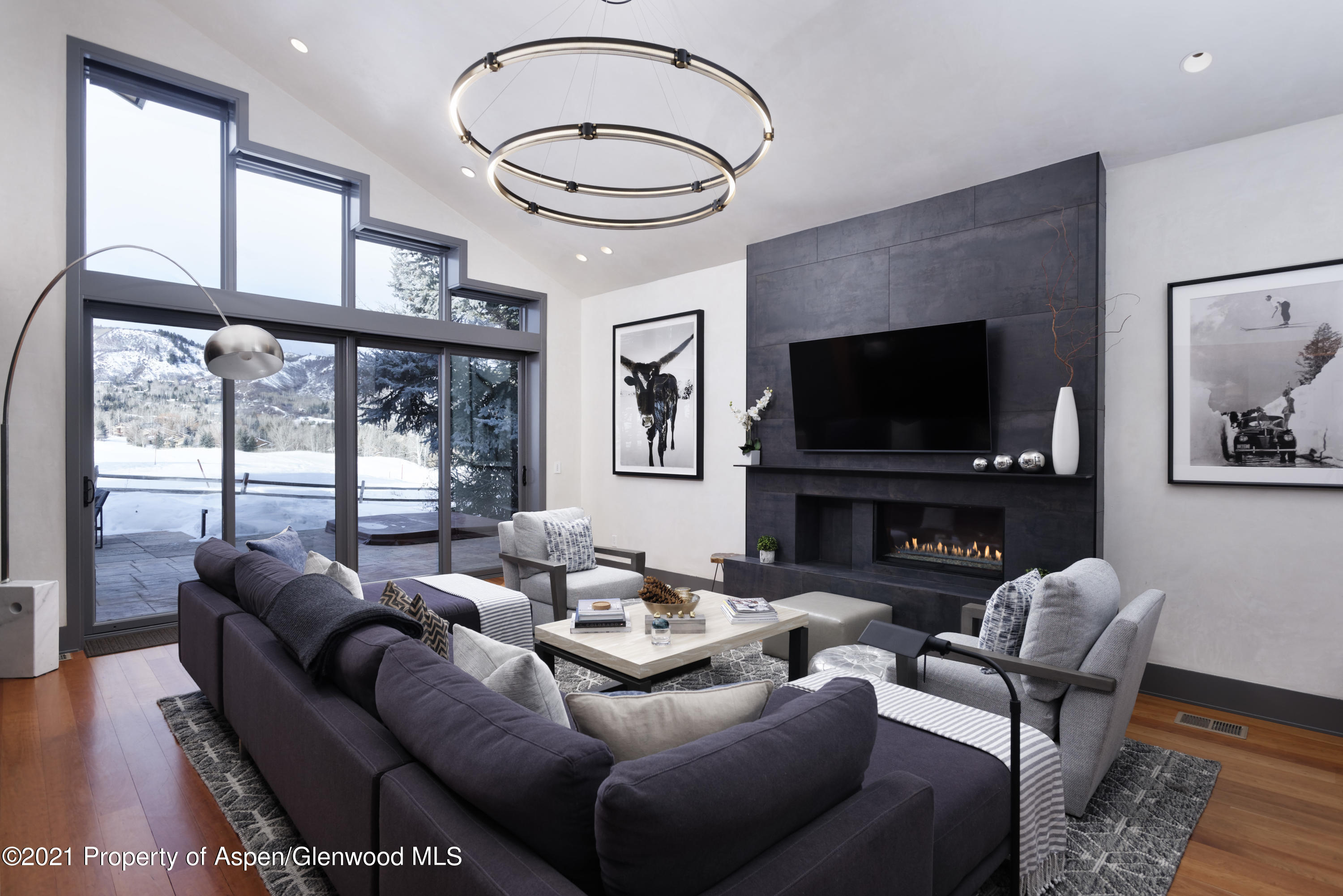 a living room with furniture a large window and a flat screen tv