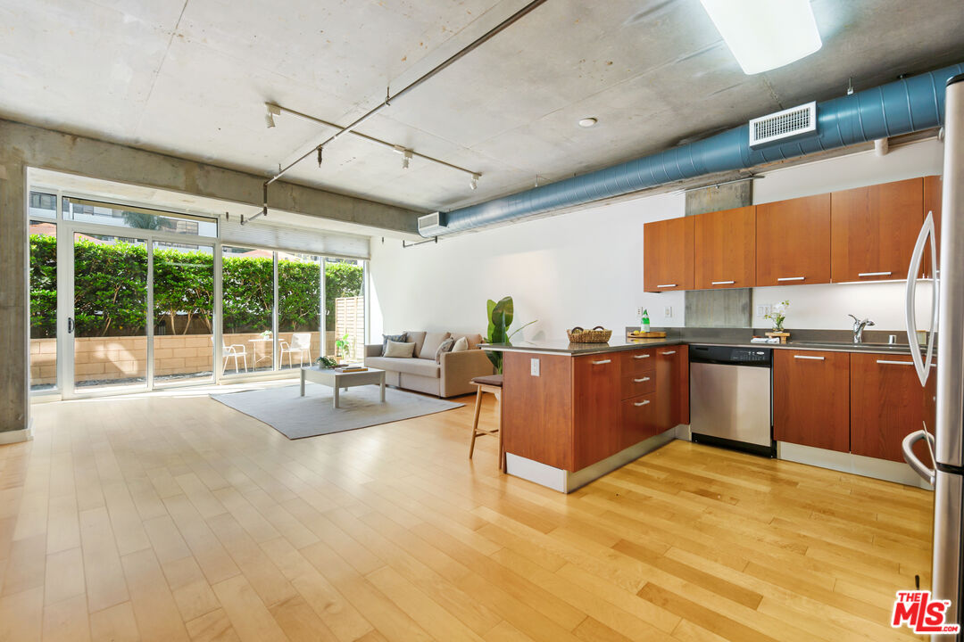 a living room with furniture a large window with kitchen view