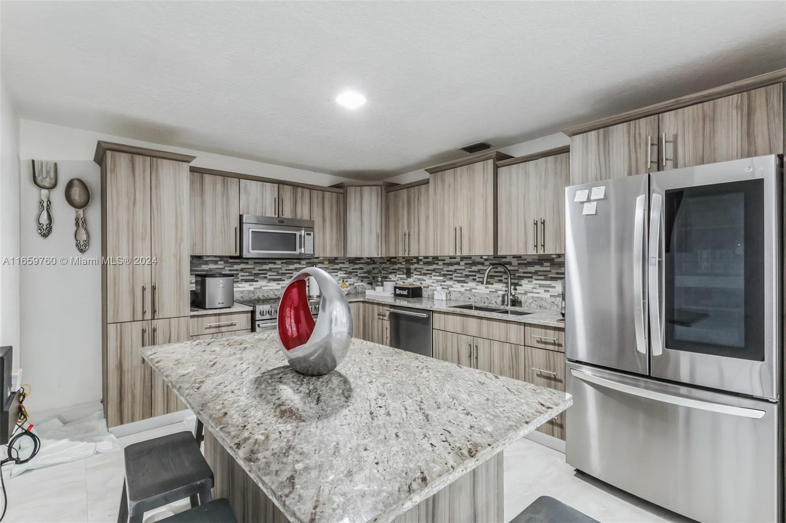 a kitchen with stainless steel appliances granite countertop a refrigerator sink and stove