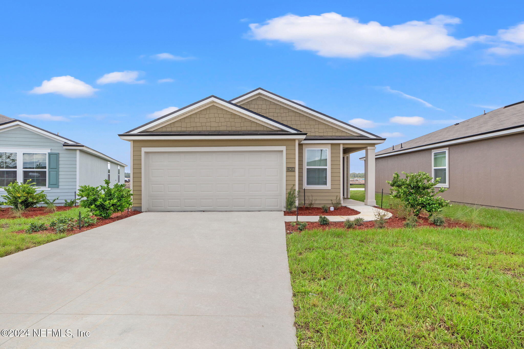 a front view of a house with a yard and garage