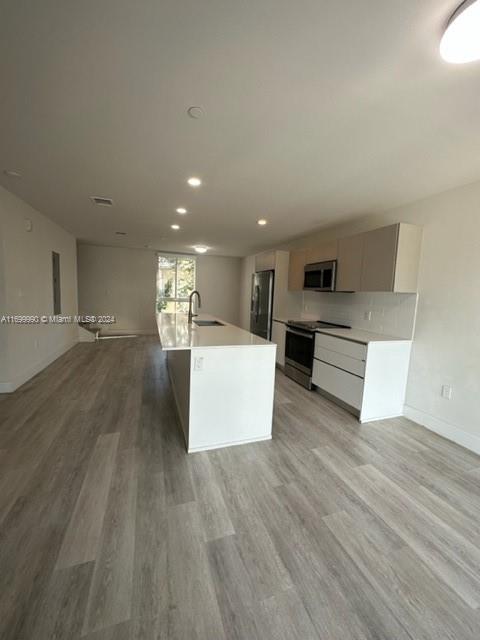 a view of kitchen with wooden floor and electronic appliances