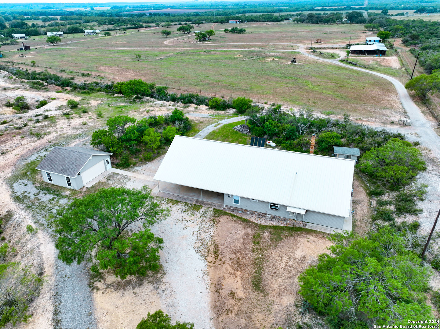 an aerial view of a house with a yard and lake view