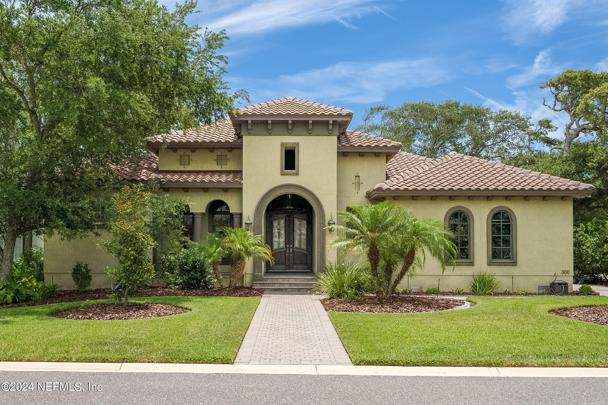 a front view of a house with a garden and plants