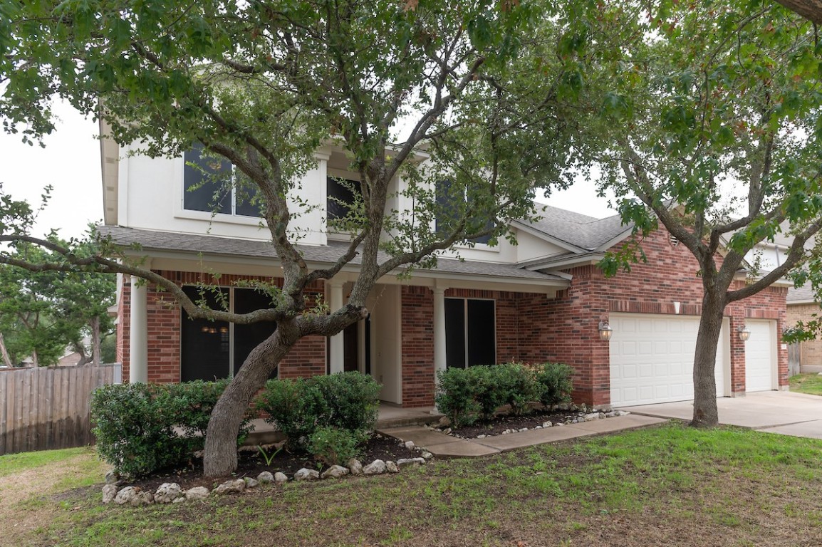 a front view of a house with a yard and potted plants