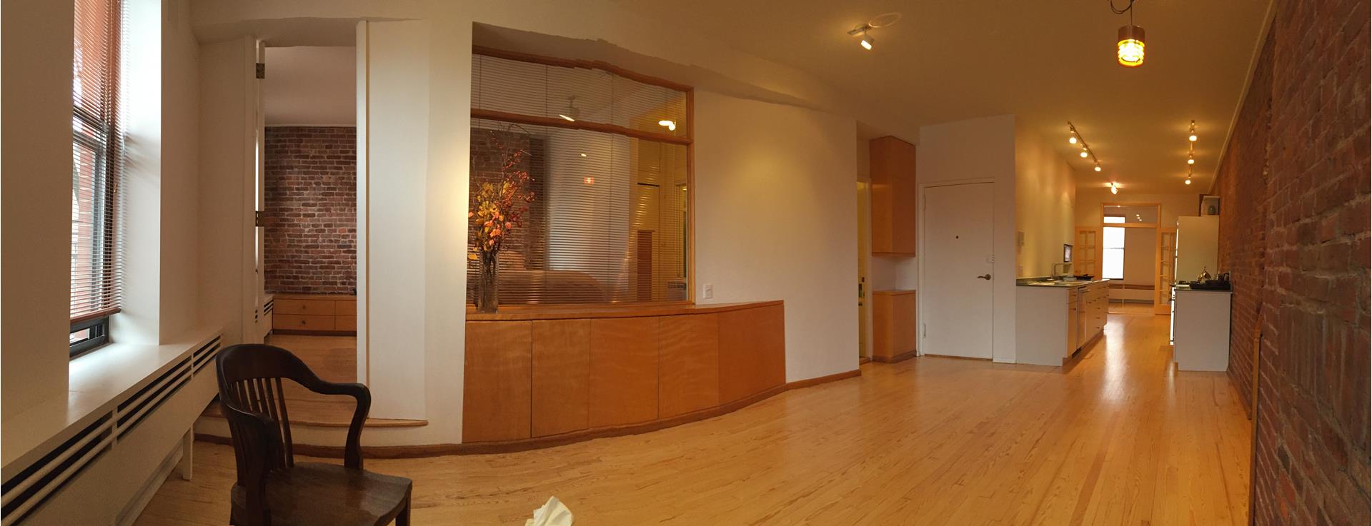 a view of a room with wooden floor and windows