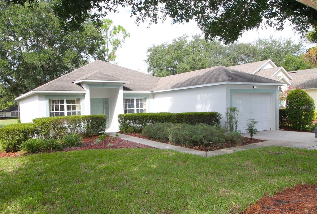 a front view of a house with a yard and green space