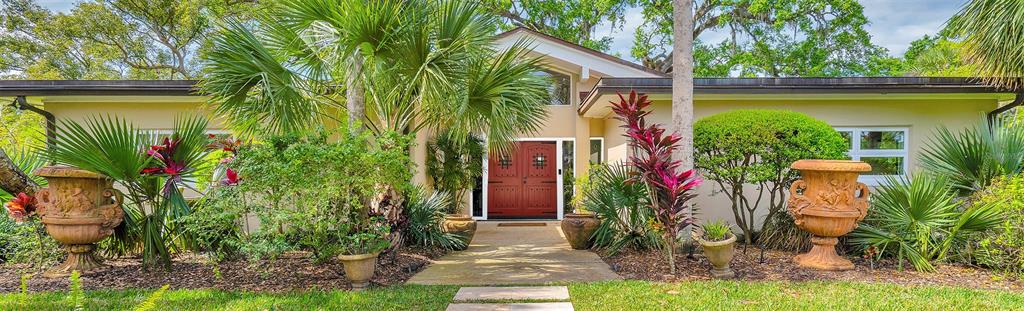 a potted plant sitting in front of a house with a yard