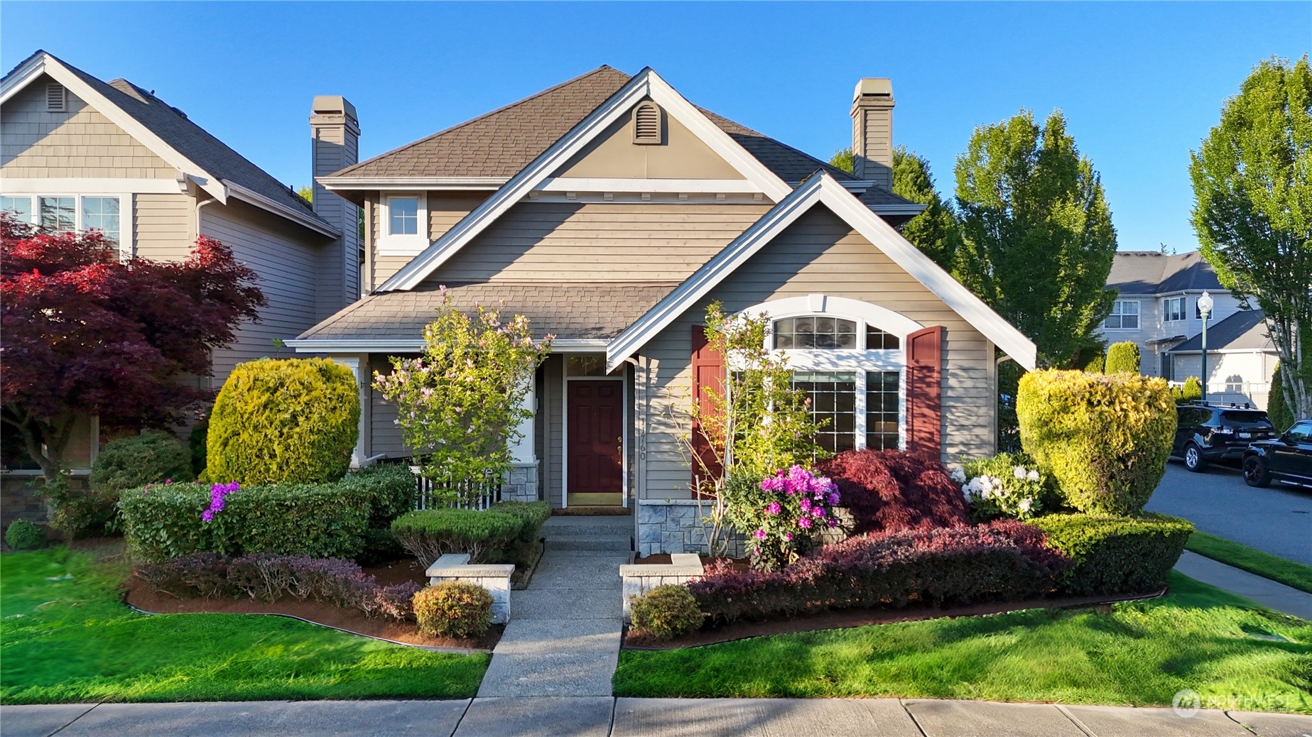 a front view of house and yard with beautiful flowers and green space