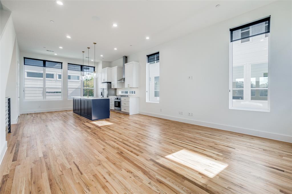 a view of empty room with wooden floor and windows