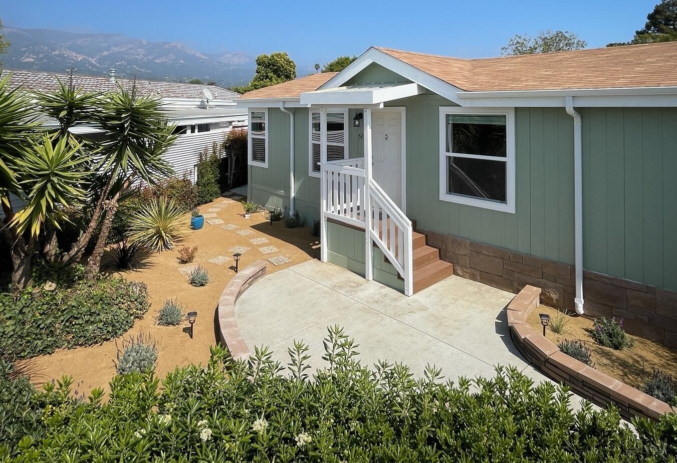 a view of a house with backyard and sitting area