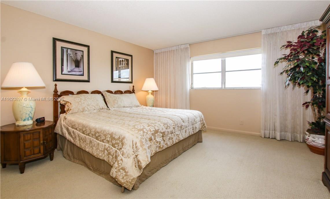 a bedroom with a bed and a potted plant next to a window