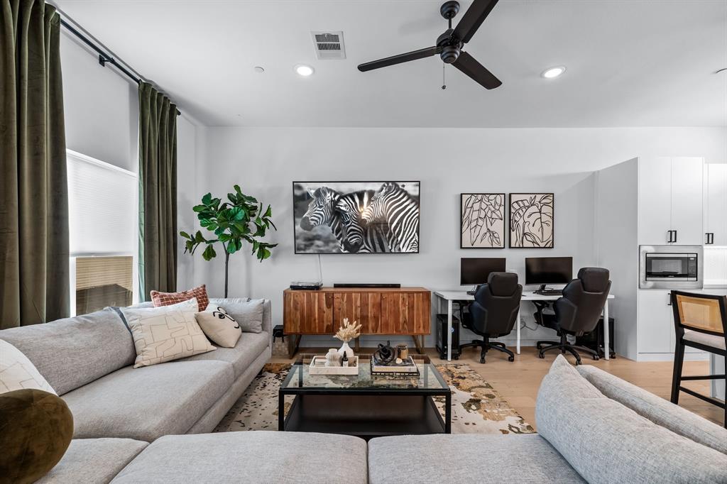 a living room with furniture ceiling fan and a window