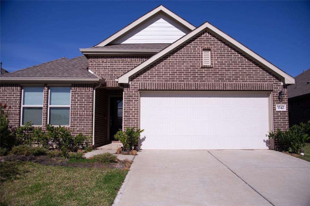 This is a modern, single-story brick home with a two-car garage. It features a well-maintained front yard and a clean, inviting exterior.