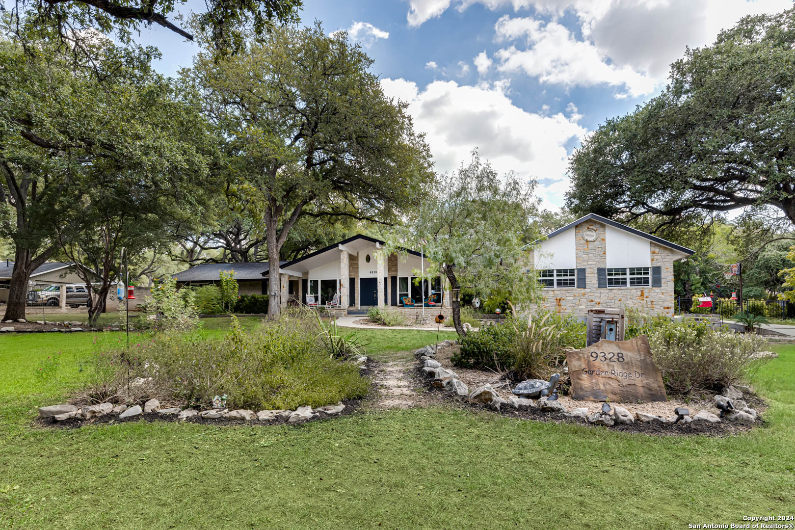 a front view of a house with a yard and trees