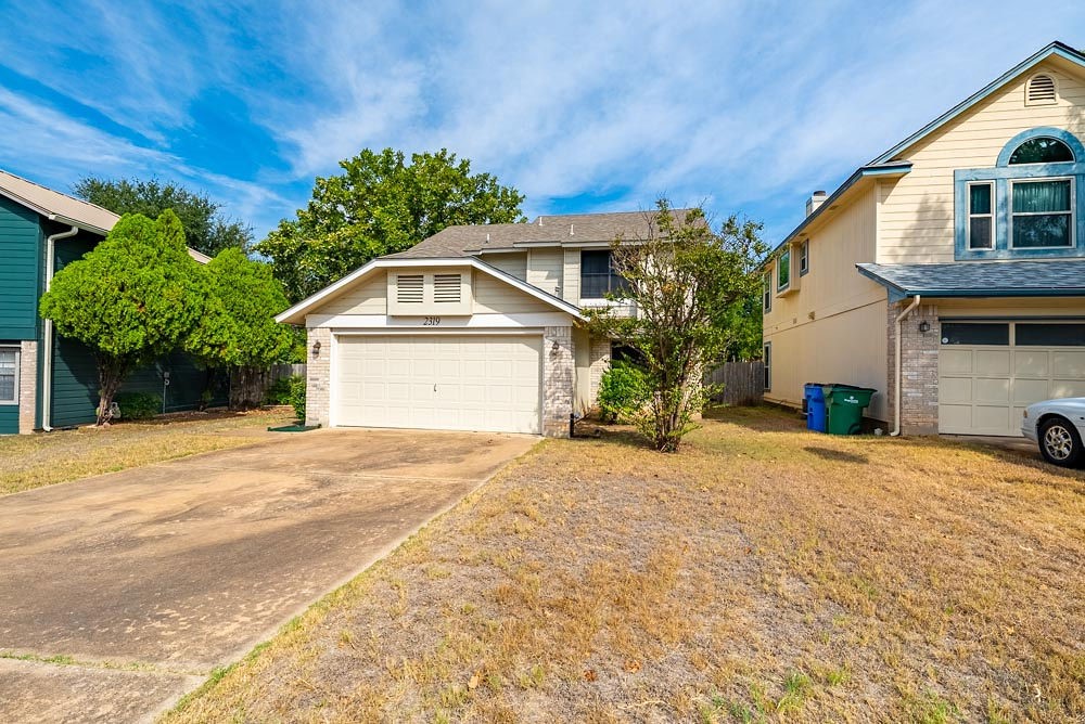 a front view of a house with a yard and garage