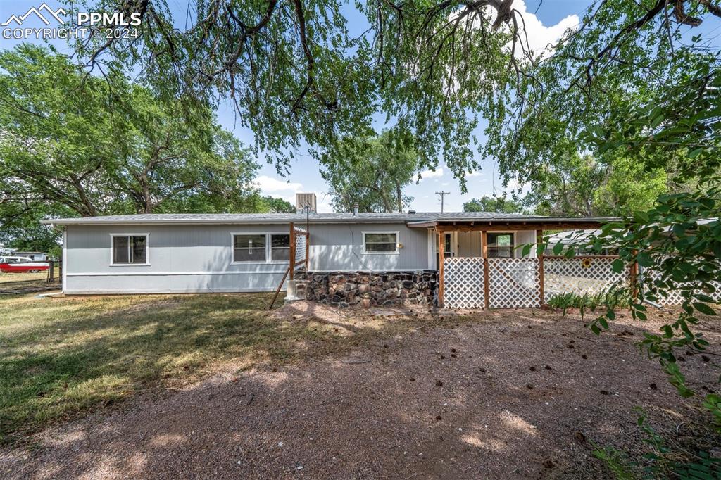 a view of house with backyard and trees