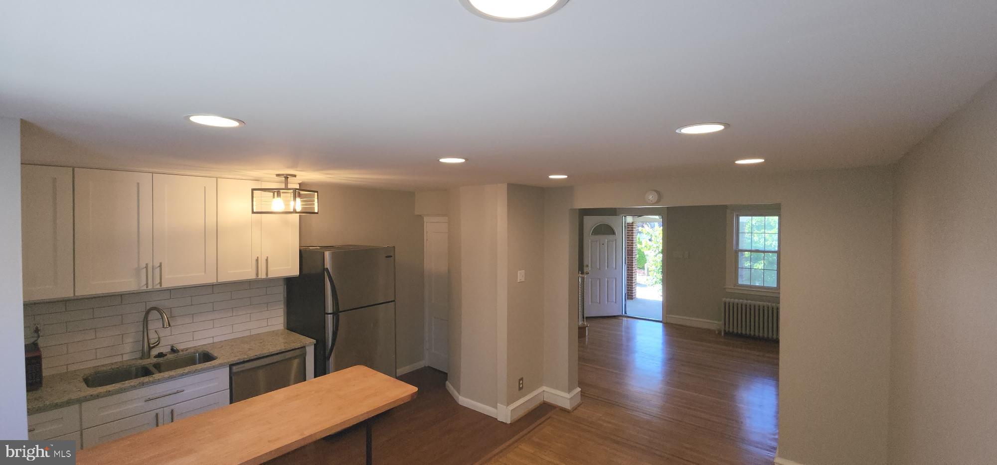 a view of a hallway to kitchen and wooden floor