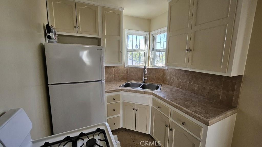 a kitchen with a refrigerator sink stove and cabinets