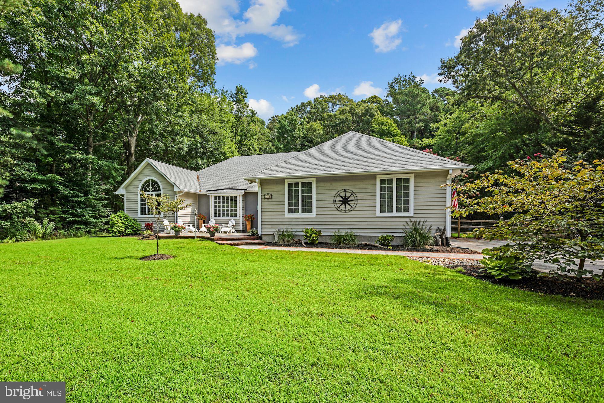 a front view of a house with yard and green space