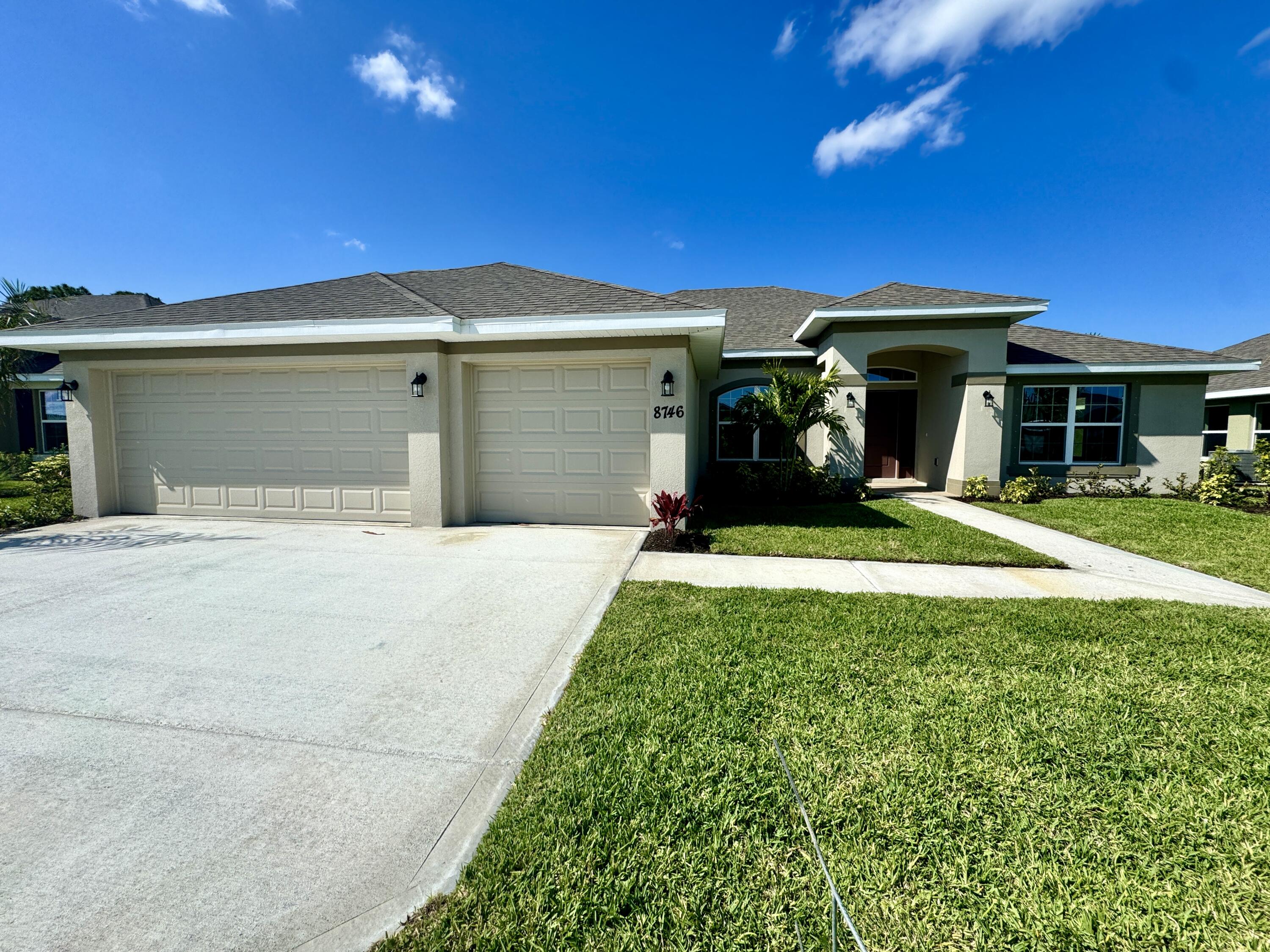 a front view of a house with a yard and garage