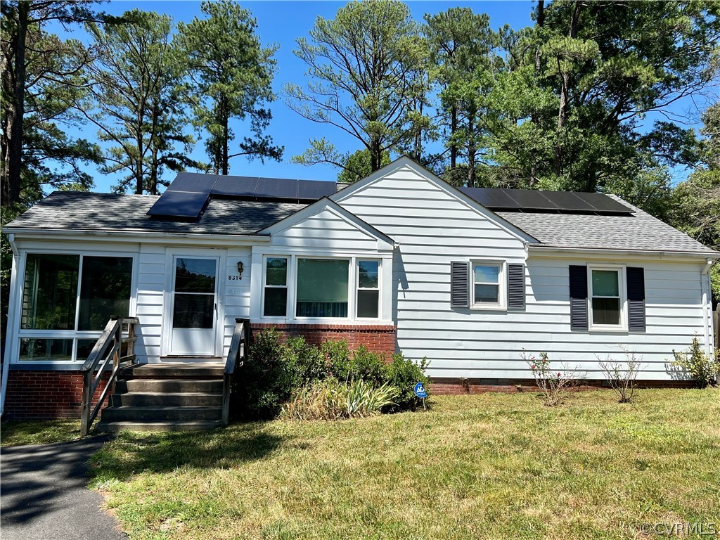 View of front of house featuring solar panels and