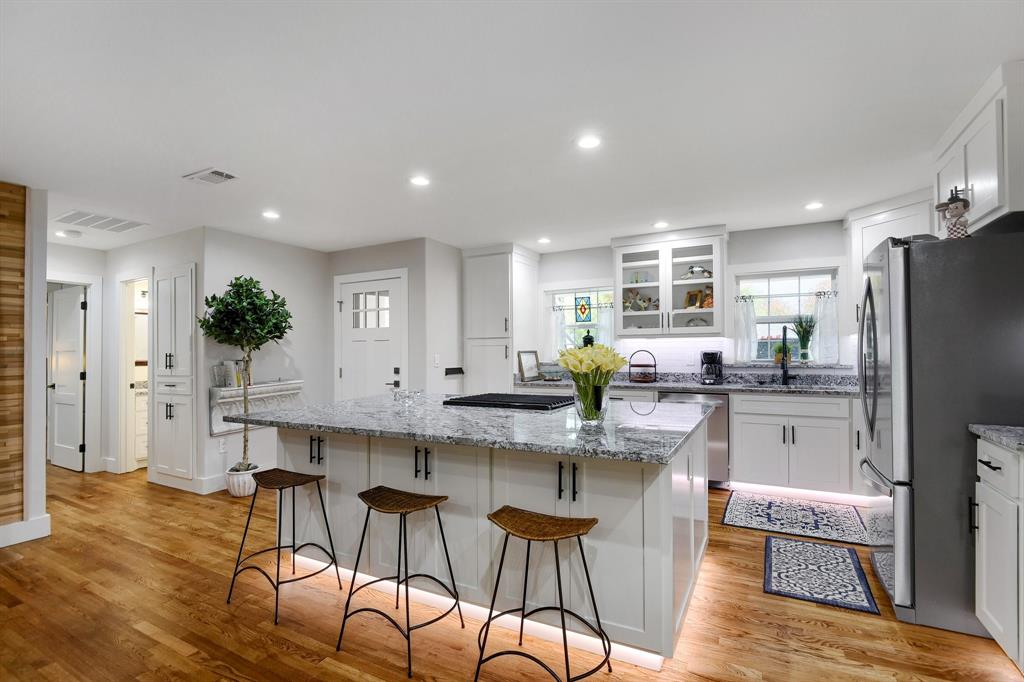 a kitchen with stainless steel appliances kitchen island granite countertop a refrigerator and a stove top oven